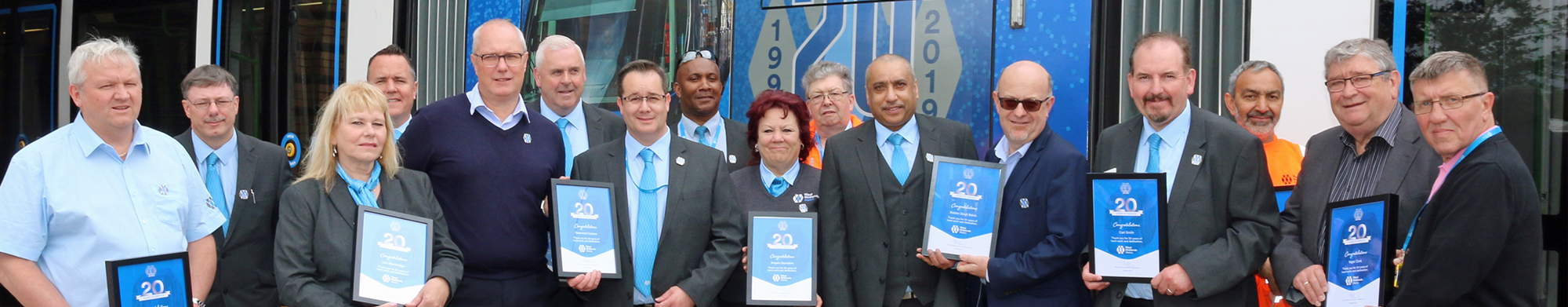 Group of people in West Midlands Metro uniform holding certificates