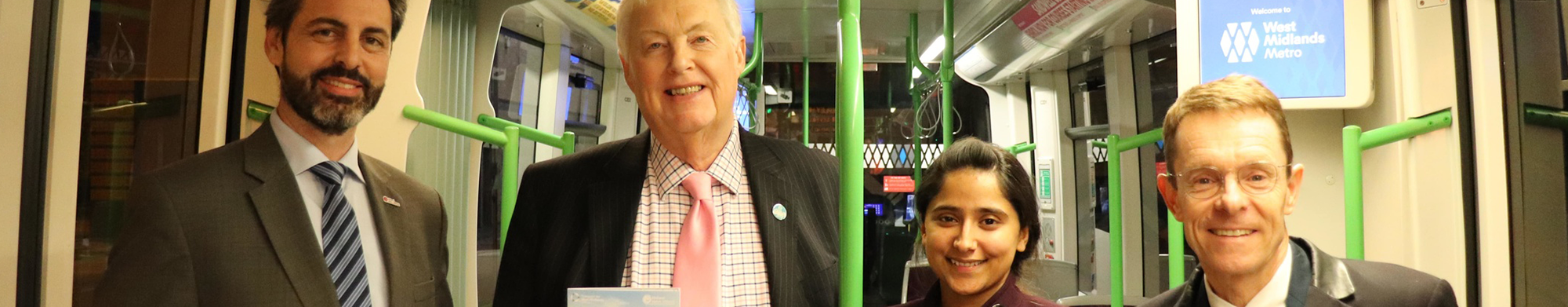 Three men and a woman smiling on the tram