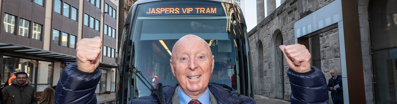 Jasper Carrott celebrating in front of tram named after him