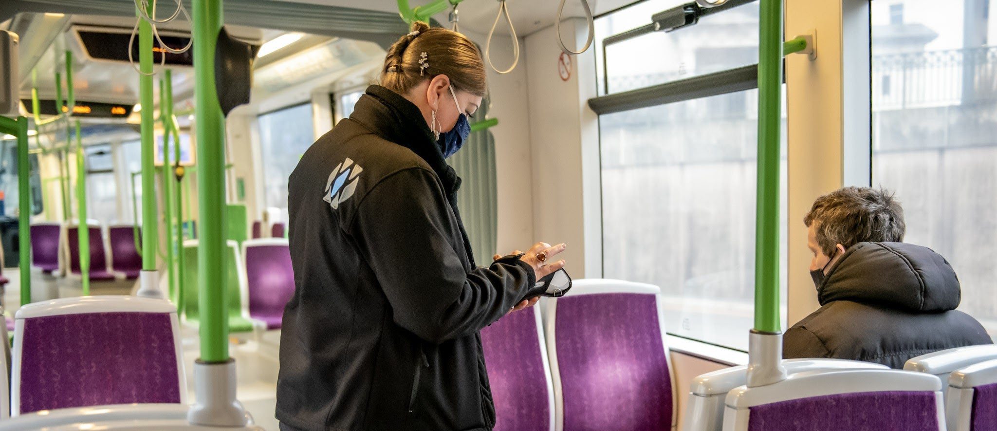 Woman working for WMM talking to passenger on tram